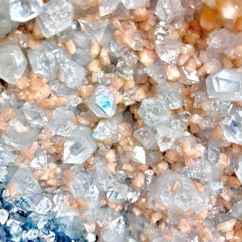 Sparkling white and peach crystals with iridescent blue accents, showcasing unique statement pieces.