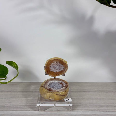 Druzy mermaid box featuring a split yellow agate geode with sparkling crystal center on a clear acrylic stand.