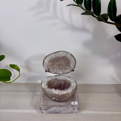 Druzy mermaid box made of split amethyst geode with sparkling crystal interior on a clear acrylic display stand.