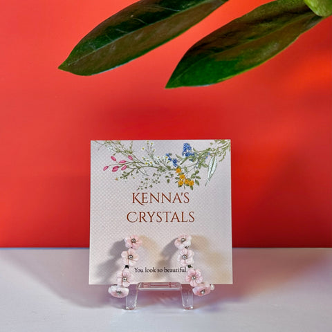 Endless Bouquet hoop earrings featuring delicate pink flower charms on silver hoops, displayed on a Kenna's Crystals card.