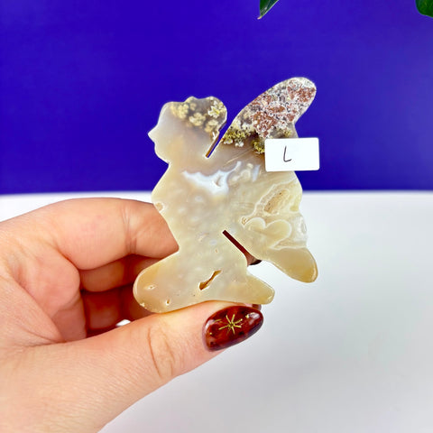 Hand-carved moss agate kneeling fairy princess figurine with translucent beige tones and natural mossy inclusions.