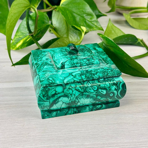 Small square malachite jewellery box with a vibrant green banded stone pattern and a matching lid handle.