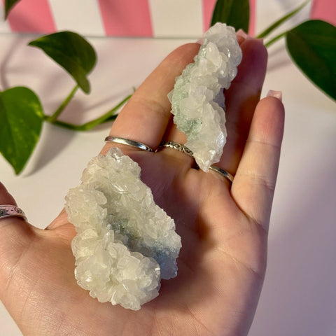 Mint-green fluorite with calcite specimen held in a hand, showing rough natural clusters.