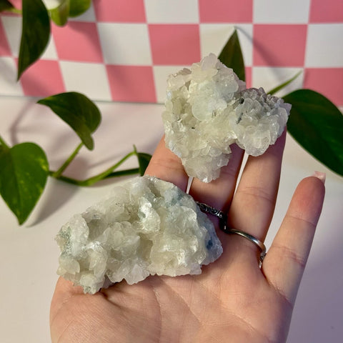 Mint-green fluorite with calcite specimen held in a hand, showing two clusters of crystals.