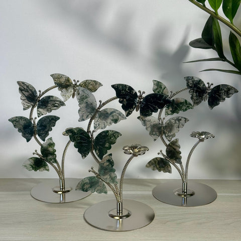 Moss agate butterfly flock with green and white wings on silver-tone metal stands.