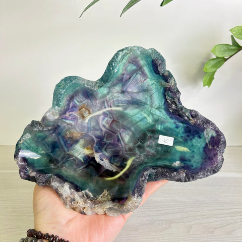 Handheld Mystic Mountain fluorite bowl featuring swirling purple and teal crystalline patterns with a natural raw edge.