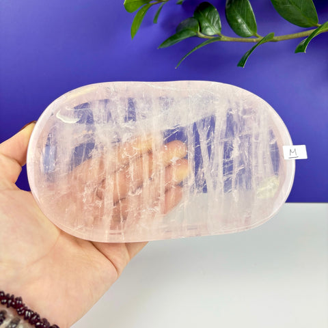 Handheld oval tray carved from translucent, pale pink rose quartz with natural crystalline textures.