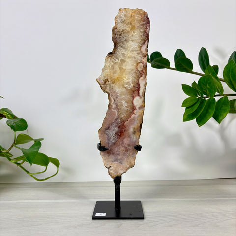 Tall, vertical pink amethyst crystal slice with crystalline center and earthy edges, displayed on a black metal stand.