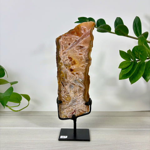 Tall, polished pink amethyst slab with intricate crystalline patterns on a black metal display stand.