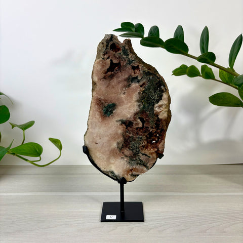 Large pink amethyst slab with mossy green inclusions, displayed on a black metal stand against a white background.