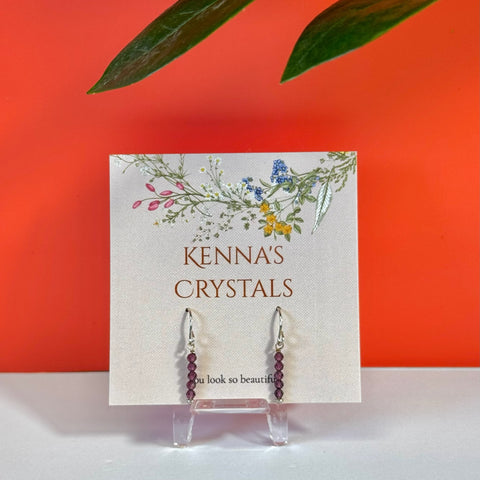 Round pink tourmaline earrings with silver hooks on a floral Kenna's Crystals card.