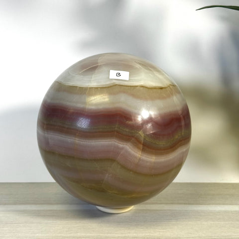 XL pink banded onyx sphere with natural color variations and a smooth, polished finish.