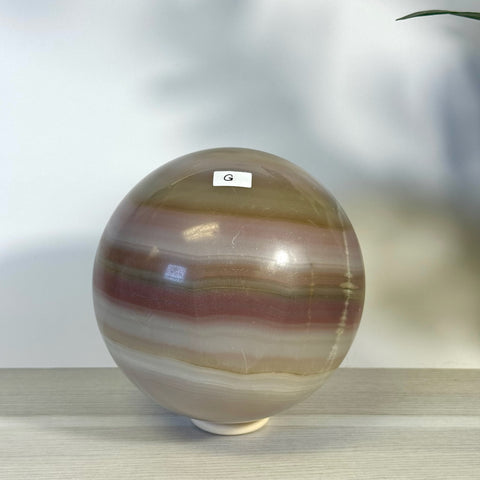 XL Pink Banded Onyx Sphere, a polished crystal ball with natural pink, white, and brown bands.