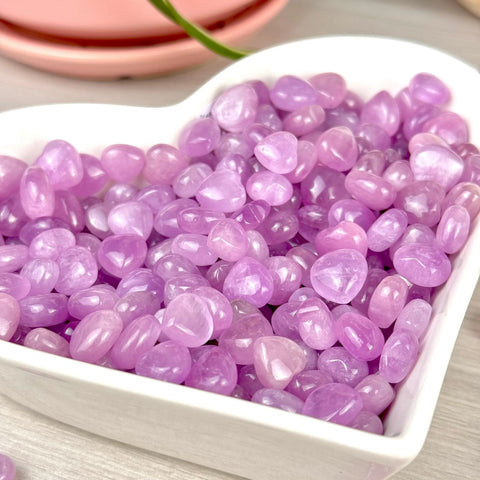 Shiny, tumbled lavender amethyst heart-shaped stones in a white dish, perfect for VIP gift add-ons.