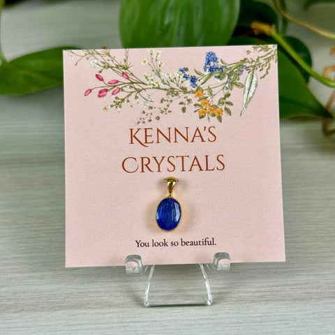 Kenna's Crystals December collection: a vibrant blue oval crystal pendant on a floral pink card.