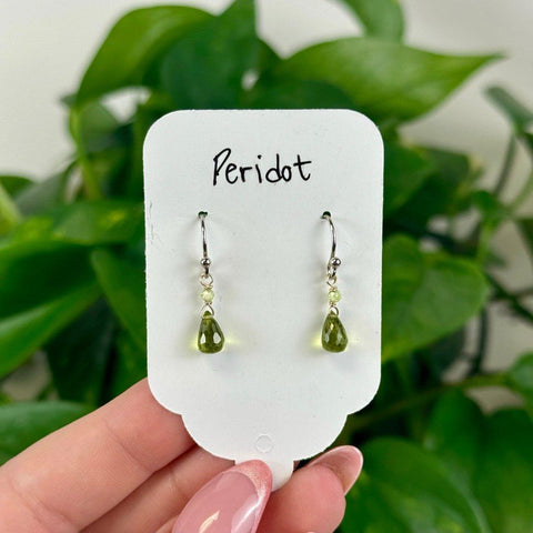 August Collection: Dainty silver earrings with vibrant green peridot teardrop gems, perfect for summer.