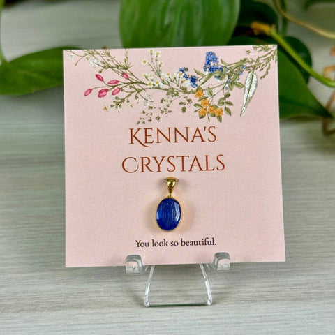Kenna's Crystals December collection: a vibrant blue oval crystal pendant on a floral pink card.