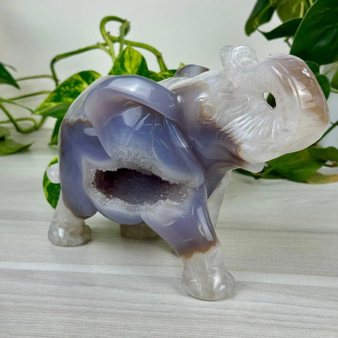 Carved purple and white agate elephant with a sparkling geode cavity, embodying rare finds.