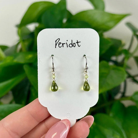 August Collection: Dainty silver earrings with vibrant green peridot teardrop gems, perfect for summer.