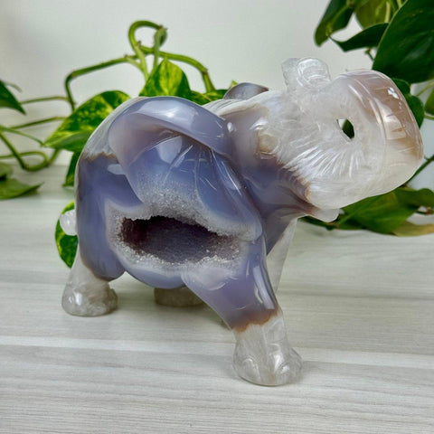 Carved agate elephant with a geode cavity, showcasing natural purple, white, and brown hues.
