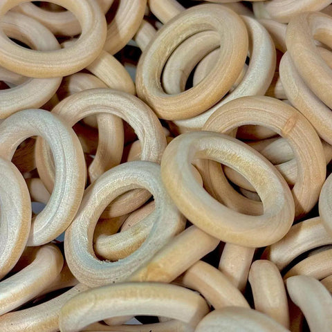 Pile of smooth, light-colored wooden rings, ideal for craft stands and accessories.