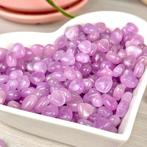 Shiny, tumbled lavender amethyst heart-shaped stones in a white dish, perfect for VIP gift add-ons.