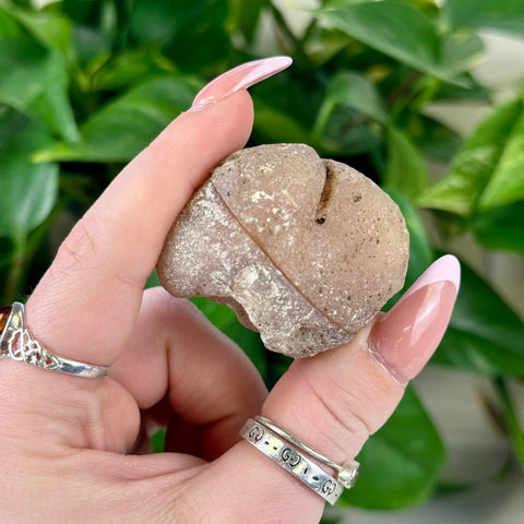 Natural brown agate pair, M2-X3, held in hand, showing rough texture and split design.