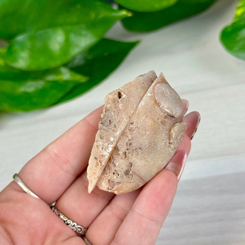 Natural beige and brown agate pair with rough edges, held in a hand.