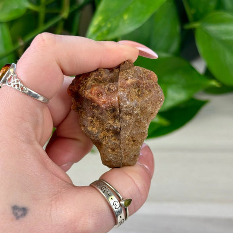 Rough brown agate pair held in hand, showing natural texture and earthy tones.
