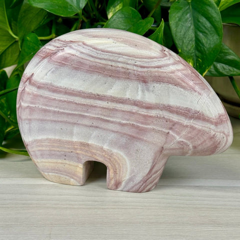 Antonelli The Bear carving in rainbow rhyolite, featuring swirling pink and white bands.