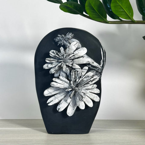 Black Chrysanthemum Stone free form with white floral patterns, displayed on a light wooden surface.