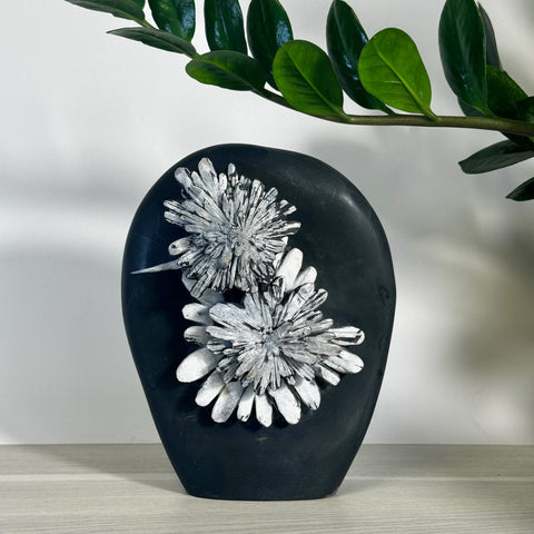 Black chrysanthemum stone free form with two white floral patterns.