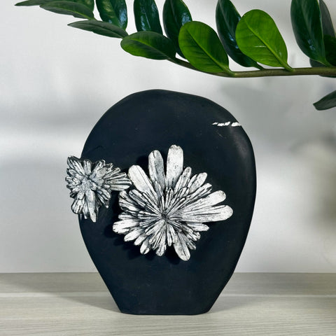 Black chrysanthemum stone free form with two white floral patterns.