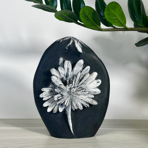 Black chrysanthemum stone free form with white floral pattern.