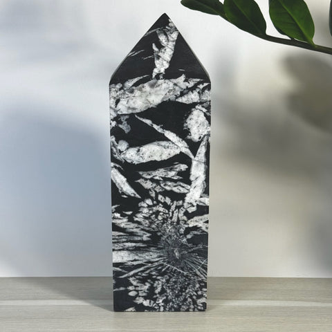 Black and white Chrysanthemum Stone Tower with striking floral patterns and a pointed top.