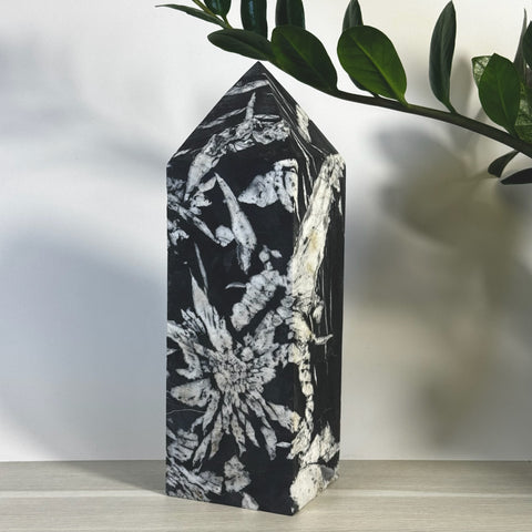 Black and white Chrysanthemum Stone Tower, a polished crystal obelisk with floral patterns.