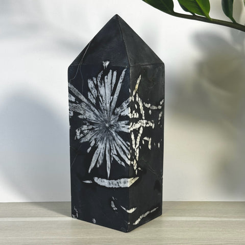 Black Chrysanthemum Stone Tower with striking white floral patterns, polished finish.