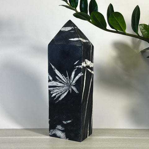 Black Chrysanthemum Stone Tower with white floral patterns, polished finish, and pointed top.