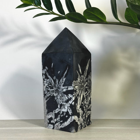 Black Chrysanthemum Stone Tower with white floral patterns, polished finish.