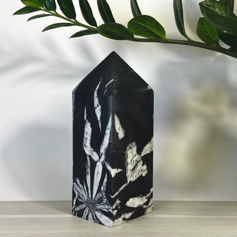 Black Chrysanthemum Stone Tower with white floral patterns, polished finish.