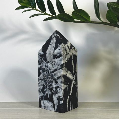 Black and white Chrysanthemum Stone Tower with unique floral patterns, polished finish, and pointed top.