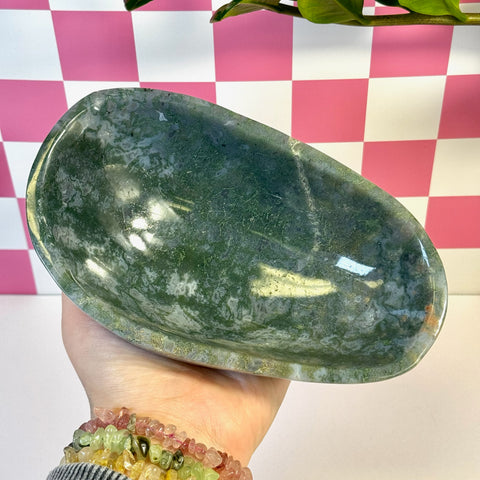 Curvy moss agate bowl, deep green with natural white patterns, held in a hand.