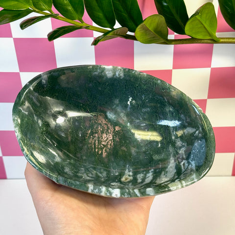 Curvy moss agate bowl with deep green and white natural patterns, held in a hand.