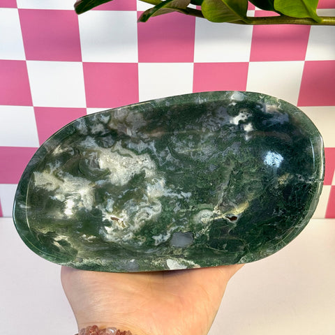 Curvy moss agate bowl with deep green and white natural patterns, held in a hand.