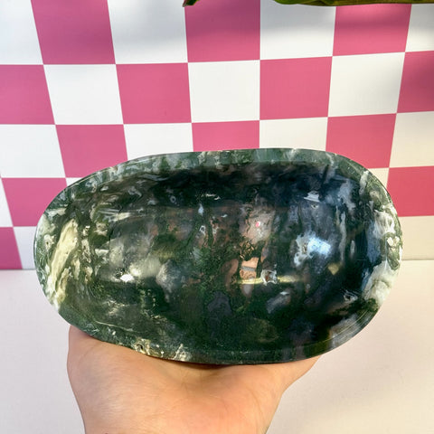 Curvy moss agate bowl with deep green and white natural patterns, held in a hand.