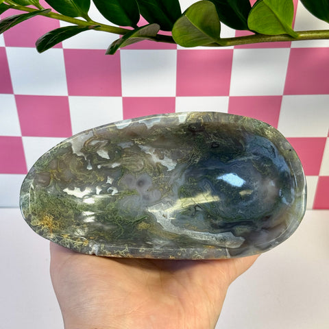 Curvy moss agate bowl with natural green, white, and brown patterns, held in a hand.