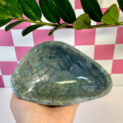 Curvy moss agate bowl with natural green and white patterns, held in a hand.