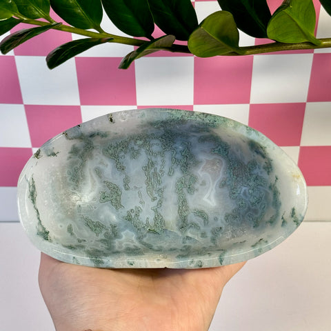 Curvy moss agate bowl with natural green and white patterns, held in a hand.
