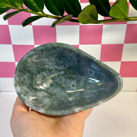 Curvy moss agate bowl, teardrop shape, with natural green and white patterns, held in a hand.