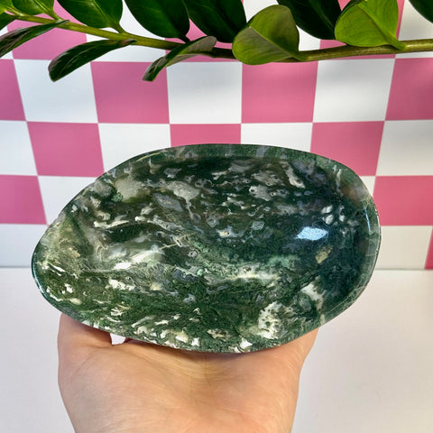 Curvy moss agate bowl, deep green with white inclusions, held in a hand.